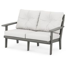 a gray and white couch sitting on top of a wooden frame