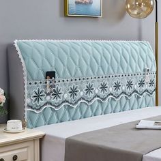 a bed with a blue headboard sitting on top of it