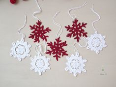 crocheted snowflakes hanging from strings on a table