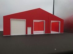 a red building with two garages on the side and one door open to let in light