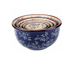 four blue and white bowls stacked on top of each other, with floral designs in the middle