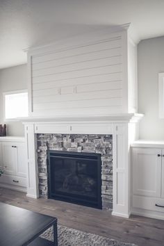 a living room with a fireplace and white cabinets