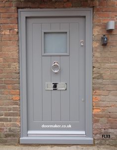 a grey door on the side of a brick building