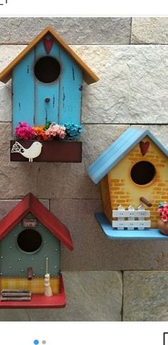 three bird houses are hanging on the wall