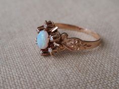 Antique Opal Diamond Ring 10k.  This elegant lady is from around the early 1900s.  She has a gorgeous center oval opal that is surrounded by 6 dainty rose cut diamonds.  She is a size 7 and weighs 2.3g.  The center stone measures approx. 6mm x 5mm and her overall setting is 11.4mm north to south.  She appears to be in wonderful shape for her age although, as expected with her age, there is some wear to the opal, please see pictures. She is unmarked and has tested as 10k.  She would make a stunni Victorian Oval Opal Ring For Anniversary, Victorian Opal Oval Cabochon Ring For Wedding, Victorian Oval Cabochon Opal Wedding Ring, Victorian Opal Ring For Wedding, Victorian Oval Opal Ring For Wedding, Victorian Style Oval Opal Ring For Wedding, Vintage Oval Opal Wedding Ring, Victorian Diamond Ring, Opal Diamond Ring