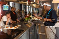 several people are standing in a restaurant kitchen