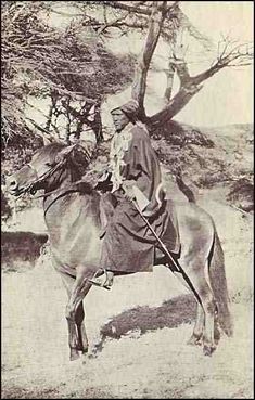 an old black and white photo of a man on a horse