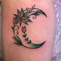 a tattoo design on the thigh of a woman's leg with flowers and leaves