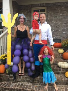 two adults and one child are standing on the steps with balloons in front of them