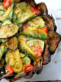 an eggplant, tomato and zucchini dish on a white platter