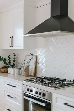 a stove top oven sitting inside of a kitchen next to white cabinets and counter tops