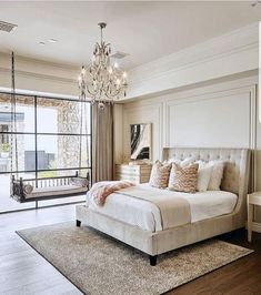 a bedroom with a bed, chandelier and large glass doors leading to a balcony