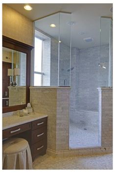 a large bathroom with a walk in shower next to a sink and vanity counter top