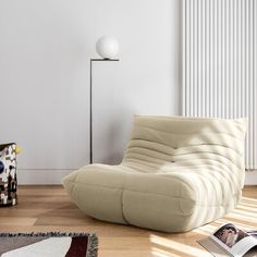 a white chair sitting on top of a hard wood floor next to a radiator