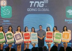 a group of women holding up signs in front of a stage with people standing behind them