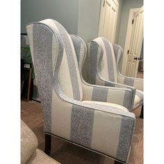 two striped chairs sitting next to each other in a room with carpeted flooring