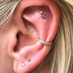 a close up of a person with ear piercings on their ears and behind the ear