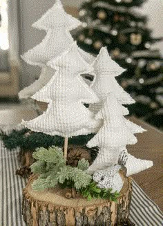 a white christmas tree sitting on top of a wooden stump