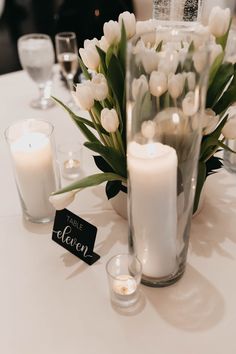 white flowers and candles on a table with a name tag that says love is bloom