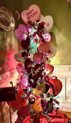 a decorated christmas tree with lots of heart shaped balloons