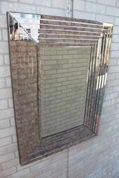 a mirror hanging on the side of a brick wall