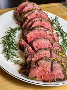 sliced steak with herbs on a white plate