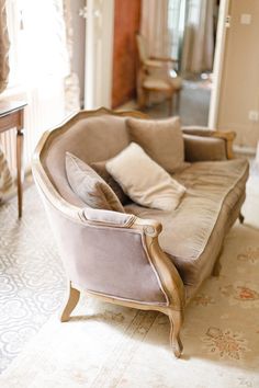 a living room with a couch, chair and mirror on the wall next to it