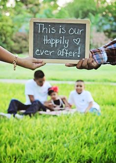 a person holding a sign that says this is our happily ever after with other people in the background