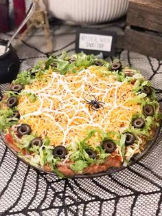 a pizza topped with cheese and olives on top of a table