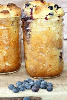 two jars filled with blueberry cobble sitting on top of a wooden table