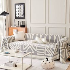 a living room filled with furniture next to a white table and window covered in blinds