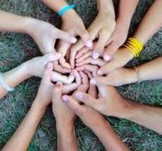 several people holding their hands together in a circle