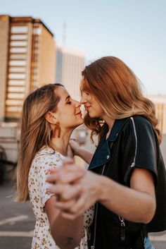 two women are standing close to each other and one is kissing the other's cheek