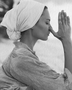 a woman with a towel on her head is holding her hands up to her face