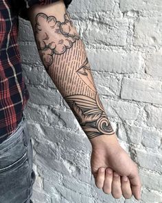 a man with a tattoo on his arm and hand holding something in the other hand