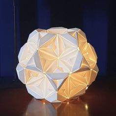 a white origami ball sitting on top of a wooden table