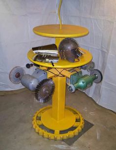 a yellow stand with several different types of tools on it's sides and wheels