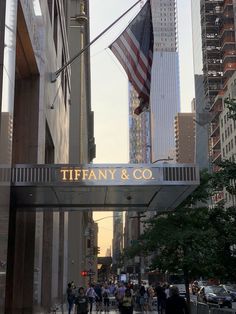 the entrance to tiffany & co in new york city, ny with people walking under it