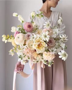 a woman holding a bouquet of flowers in her hands