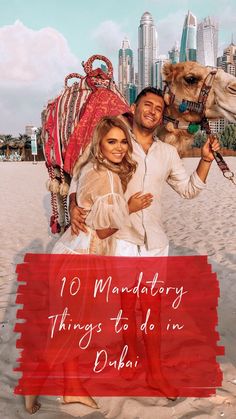 a man and woman pose with a camel on the beach