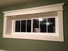 an empty room with green walls and white trim on the window sill is shown