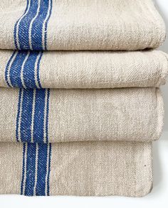 three towels folded on top of each other in blue and white stripes are stacked next to each other