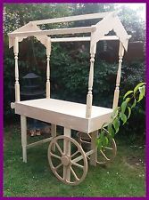 a wooden cart with a canopy on it's back and wheels attached to the sides