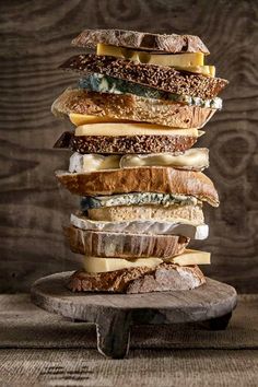 a stack of different types of bread on top of each other with cheese and meat