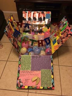 a birthday cake made out of balloons and pictures with candles in the middle, on a tile floor