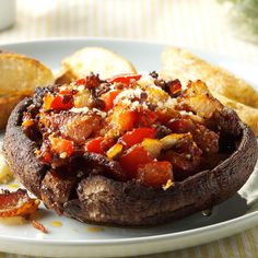 a close up of a plate of food with bread and potatoes on the table in the background