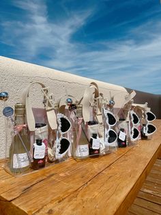 a group of bottles sitting on top of a wooden table next to a white wall