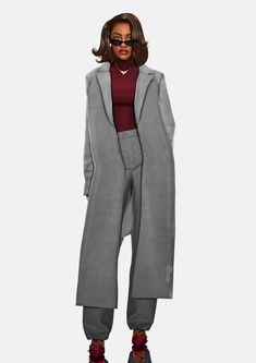 a woman in grey coat and pants standing