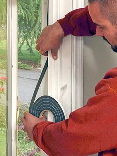 a man is opening the window with a tape