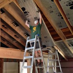 a man standing on a ladder working on the ceiling